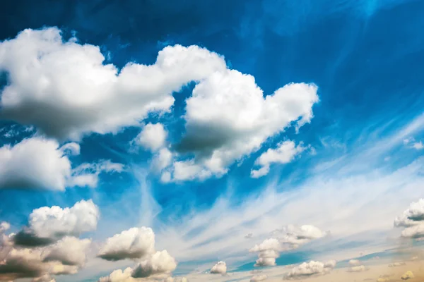 Witte pluizige wolken op blauwe hemel — Stockfoto