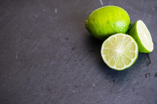 Lime fruits on blackboard — Stock Photo, Image