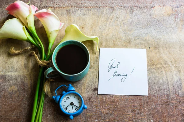 Calla flores y taza de café og en mesa rústica — Foto de Stock