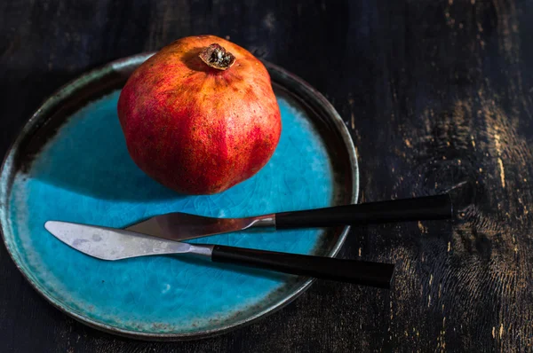Fresh pomegranate on vintage plate — Stock Photo, Image