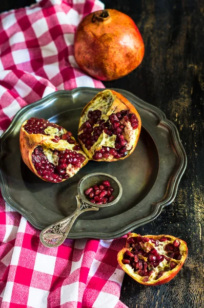 Fresh pomegranate on vintage plate — Stock Photo, Image