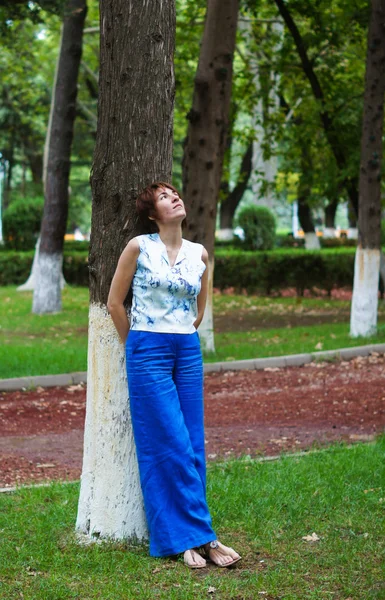 Bella donna in piedi vicino a un albero — Foto Stock