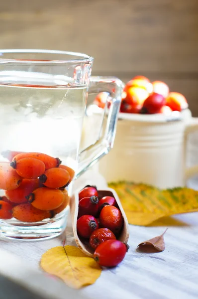 Hot hip tea with berries on the wood background — Stock Photo, Image