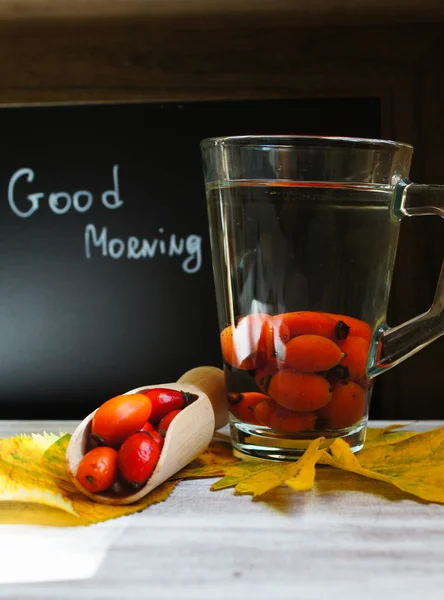 Hot hip tea with berries on the wood background — Stock Photo, Image