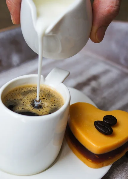 Alguém adiciona leite ao café preto — Fotografia de Stock