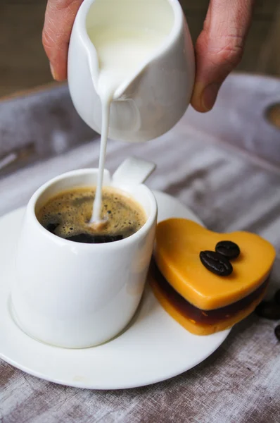 Alguém adiciona leite ao café preto — Fotografia de Stock