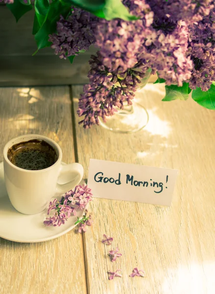 Lila bloemen en een kopje koffie — Stockfoto