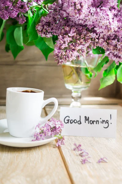 Lila bloemen en een kopje koffie — Stockfoto