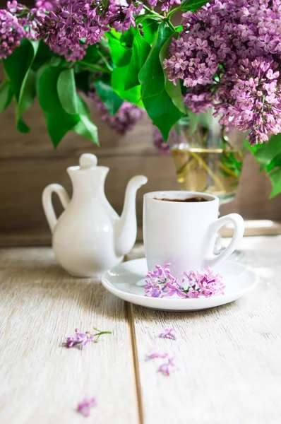 Lila bloemen en een kopje koffie — Stockfoto