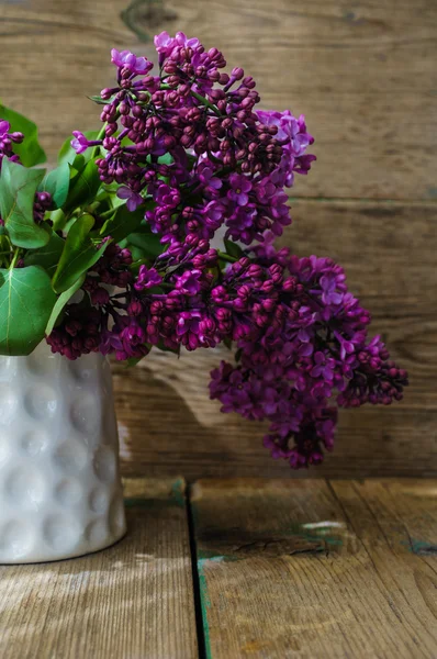 Lilac flowers in a rustic interior — Stock Photo, Image