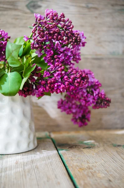 Lila blommor i en rustik interiör — Stockfoto