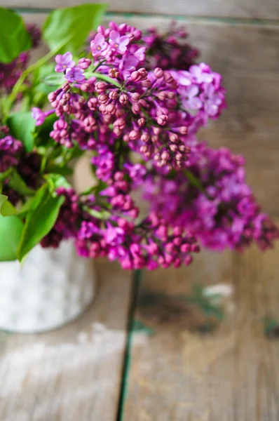 Lila blommor i en rustik interiör — Stockfoto