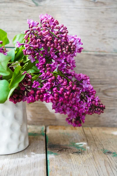 Lilac flowers in a rustic interior — Stock Photo, Image