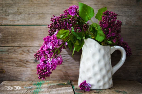 Lilac flowers in a rustic interior — Stock Photo, Image