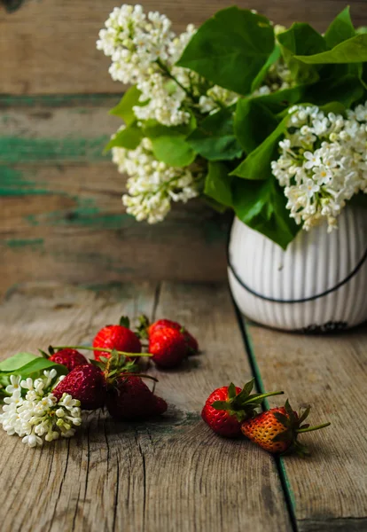 Strawberries and white lilac flowers — Stock Photo, Image