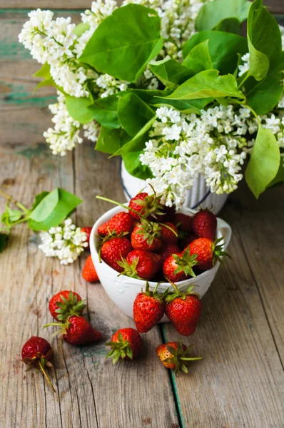 Erdbeeren und weiße Fliederblüten — Stockfoto