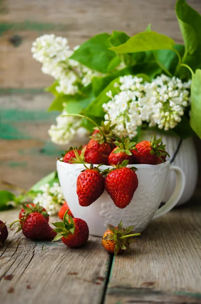 Morangos e flores brancas lilás — Fotografia de Stock