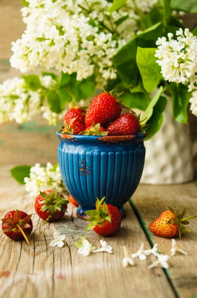 Erdbeeren und weiße Fliederblüten — Stockfoto