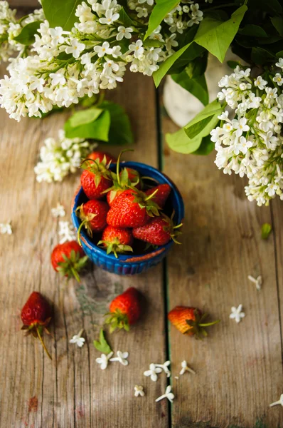 Morangos e flores brancas lilás — Fotografia de Stock