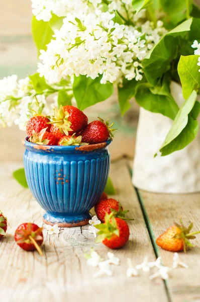 Erdbeeren und weiße Fliederblüten — Stockfoto