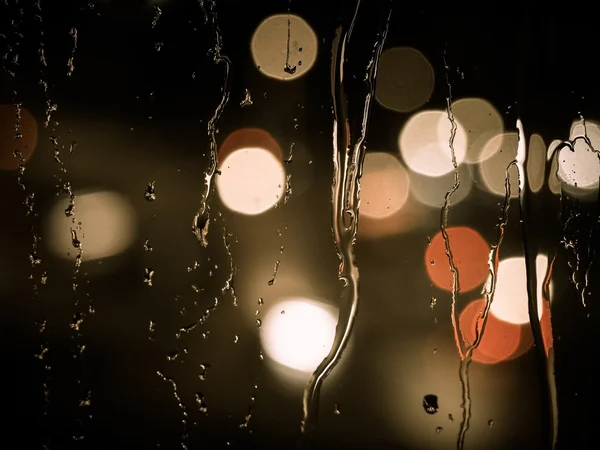 Gotas de chuva em um painel de janela à noite — Fotografia de Stock