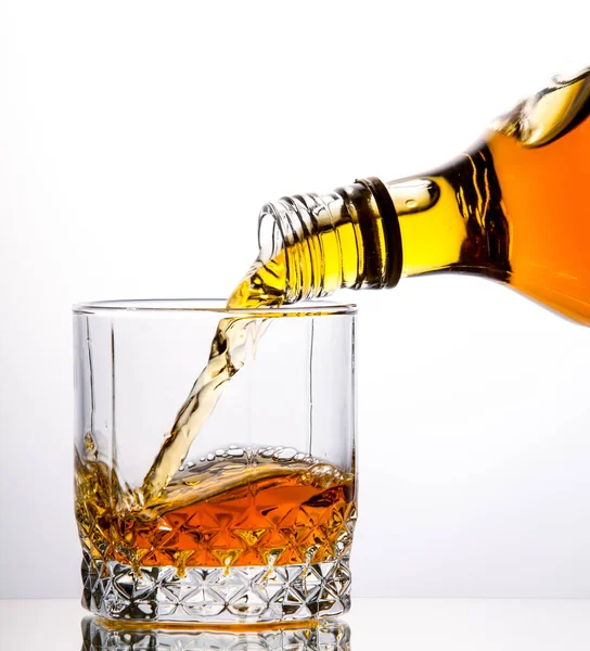 Versare Whisky Una Bottiglia Bicchiere Sfondo Bianco — Foto Stock