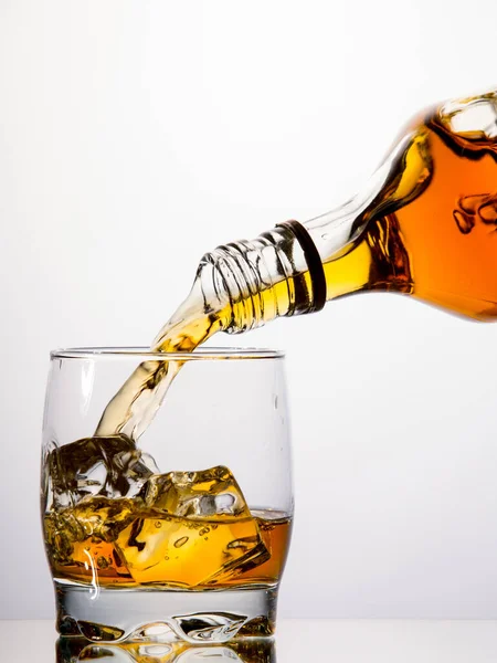 Whisky Uit Een Fles Een Tuimelaar Gieten Witte Achtergrond — Stockfoto