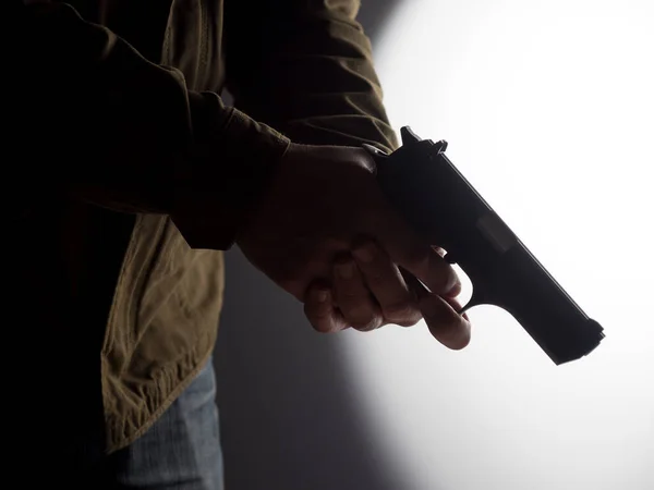 Высококонтрастное Изображение Человека Держащего Пистолет Ярко Освещенном Фоне — стоковое фото