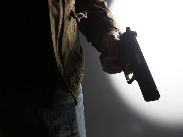 Hög Kontrast Bild Man Som Håller Pistol Mot Starkt Upplyst — Stockfoto