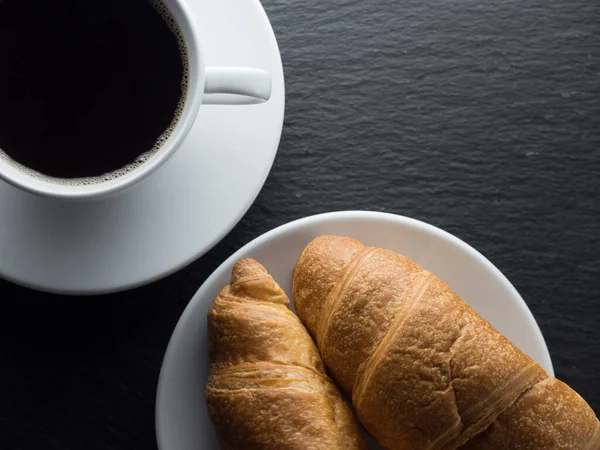 Siyah Arka Planda Bir Fincan Kahve Kruvasan — Stok fotoğraf