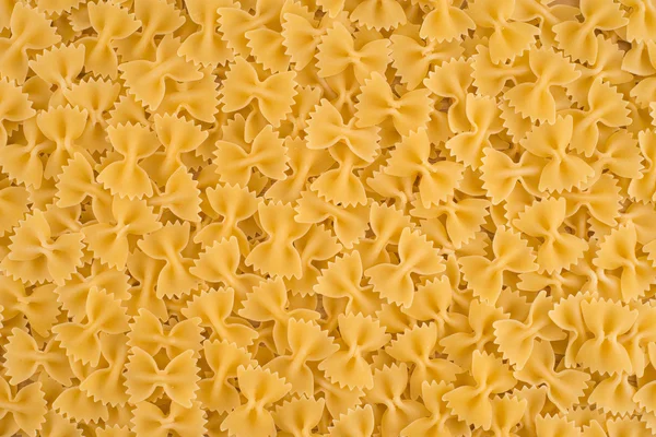 Italiano Farfalle Pasta fundo alimentos crus ou textura close-up — Fotografia de Stock