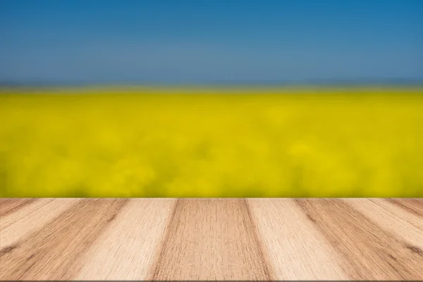 Pranchas de madeira vazias com fundo borrado florescendo estupro amarelo — Fotografia de Stock
