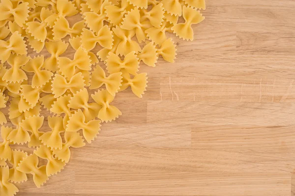Torkade italienska bowtie pasta eller farfalle över trä bakgrund — Stockfoto