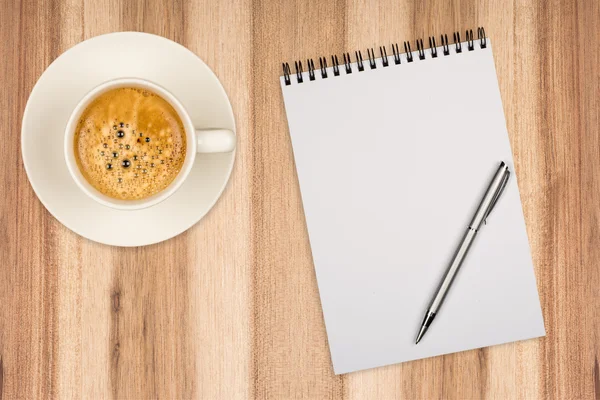 Coffee cup, spiral notebook and pen on the wooden table — Stock Photo, Image