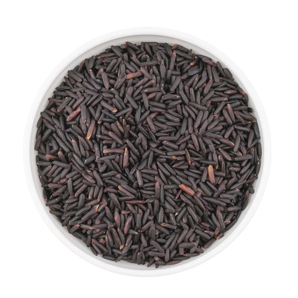 Bowl of black rice isolated on white background, top view — Stock Photo, Image