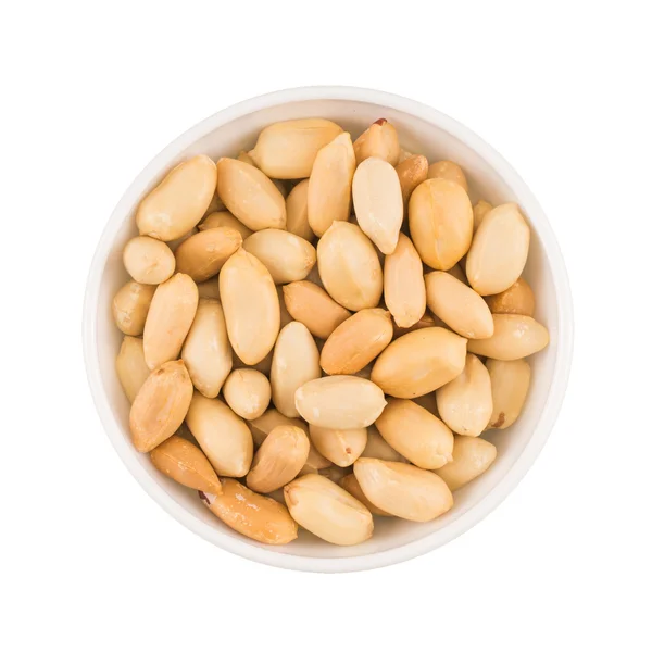 At the center of the frame white bowl roasted peanuts on a white — Stock Photo, Image