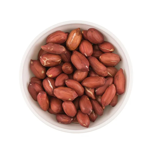 At the center of the frame white bowl roasted peanuts on a white — Stock Photo, Image