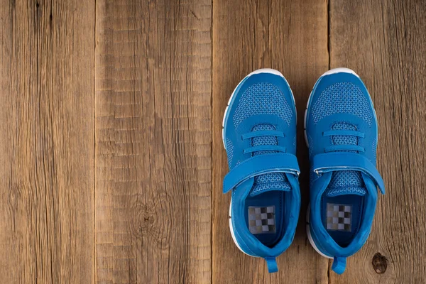 Синій Кросівки з дерев'яними тлі — стокове фото