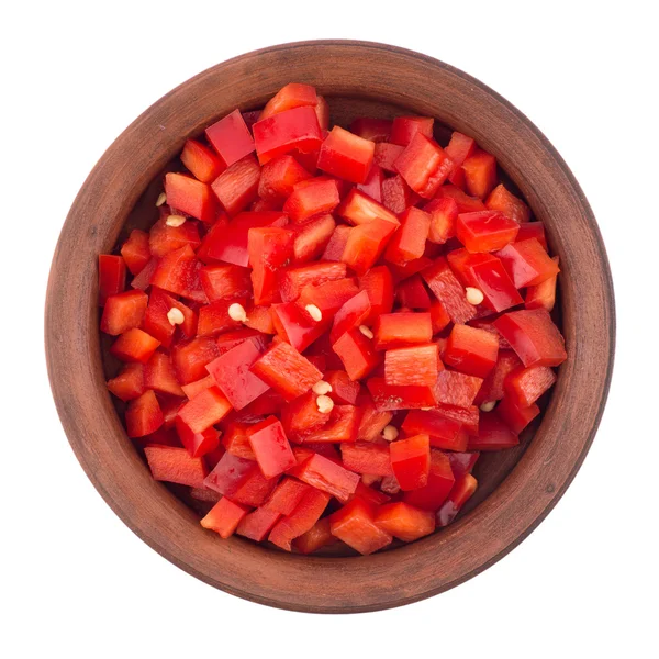 Sliced red pepper in a brown ceramic bowl. Isolated on white bac — Stock Photo, Image