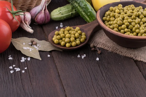 Canned peas and vegetables on an old wooden table. — Stock Photo, Image