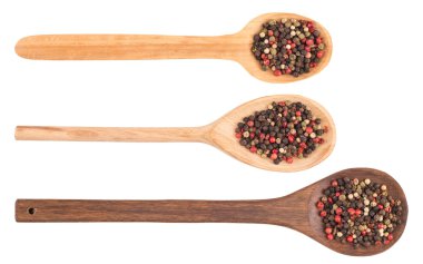 Beyaz izole bir tahta kaşık üzerinde renkli biber