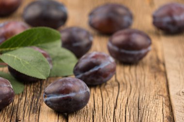 Koyu ahşap bir masa üzerinde taze Erik.