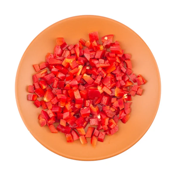 Sliced red pepper in a brown ceramic plate. Isolated on white ba — Stock Photo, Image
