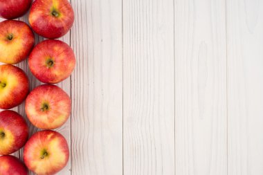 Eski ahşap masa üzerinde kırmızı elmalar. 