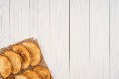 Çuval bezi ve Beyaz ahşap bir masa üzerinde kızarmış ekmek.