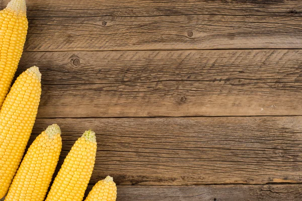 Świeża kukurydza na kolbach na rustykalnym drewnianym stole. — Zdjęcie stockowe