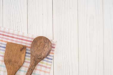 Tahta kaşık ve bir peçete ve eski bir beyaz tahta sekmesinde spatula