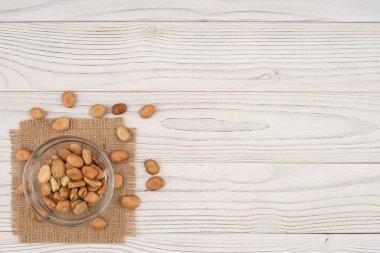 Eski ahşap masa üzerinde bir cam kabın içinde fasulye.