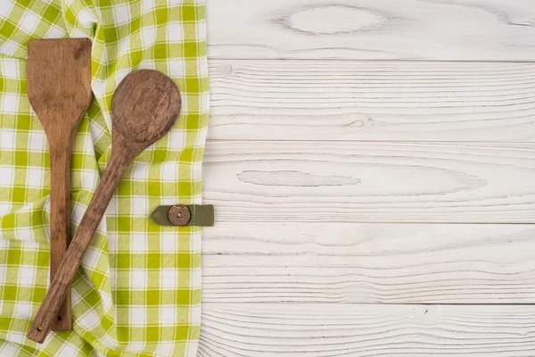 Cuchara de madera y espátula en una servilleta y una vieja lengüeta de madera blanca — Foto de Stock