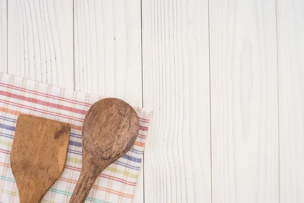 Wooden spoon and spatula on a napkin and an old white wooden tab — Stock Photo, Image